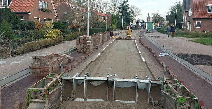 foto van de opengebroken weg met zand en stenen