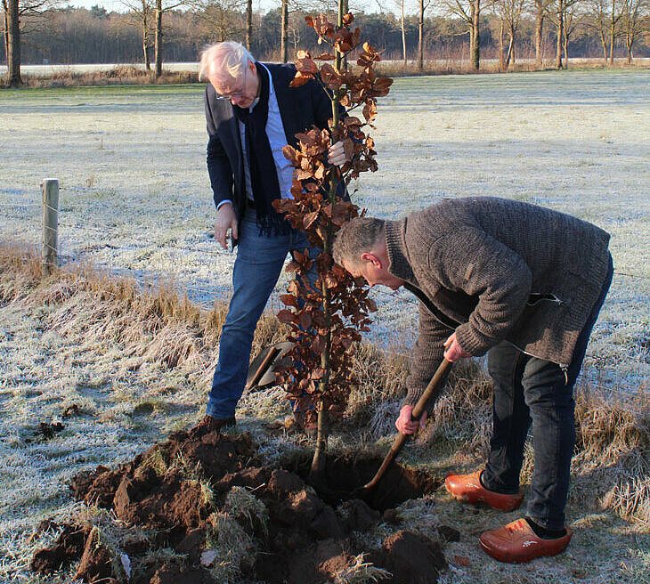 wethouder de Goede plant boom samen met een boer